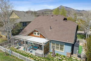 Rear view of house with a fenced backyard, an outdoor hangout area, a shingled roof, and a patio
