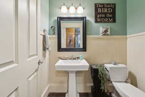 Bathroom with a sink, wainscoting, and toilet