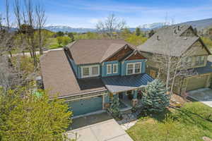 Craftsman house featuring a mountain view, covered porch, a standing seam roof, and concrete driveway
