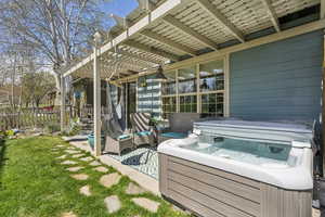 View of patio / terrace featuring a hot tub, fence, and a pergola