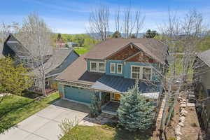Craftsman inspired home featuring a porch, a standing seam roof, metal roof, driveway, and a garage