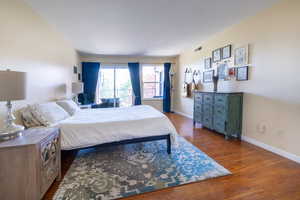 Bedroom featuring visible vents, wood finished floors, and baseboards