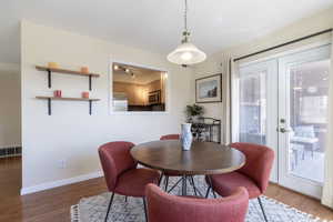 Dining space with wood finished floors, french doors, visible vents, and baseboards