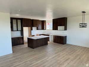 Kitchen with a center island, baseboards, and dark brown cabinetry