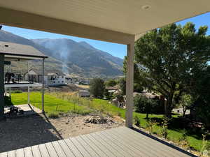 Deck featuring a yard, a mountain view, and a patio area