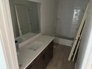 Full bathroom with vanity, tub / shower combination, and wood finished floors