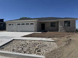 Single story home with roof with shingles, stone siding, a garage, board and batten siding, and concrete driveway
