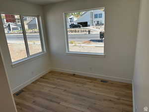 Unfurnished dining area with baseboards, visible vents, and wood finished floors