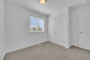 Unfurnished bedroom 2 featuring baseboards, carpet flooring, and a closet