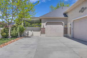 View of front of property with an attached garage, stucco siding, concrete driveway, and brick siding