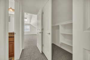 Upper level featuring full bathroom, closet, and vaulted living space