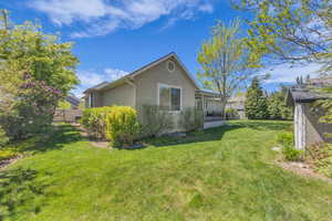 View of home's exterior featuring a yard, fence, a sunroom, and stucco siding