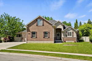 View of front of house with concrete driveway, brick siding, and an attached garage