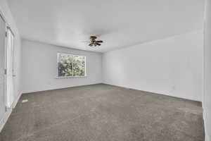 Primary bedroom with carpet floors, baseboards, and ceiling fan