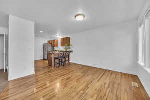 Living room with light wood-style floors, recessed lighting, baseboards, and visible vents