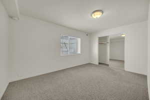 Unfurnished bedroom 5 featuring carpet floors, baseboards, and a closet