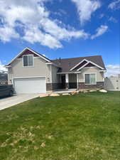 View of front of house with a garage and a front lawn