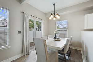Dining room featuring baseboards, a chandelier, and wood finished floors
