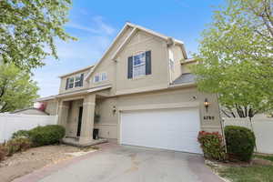 Traditional-style home featuring fence, stucco siding, and concrete driveway