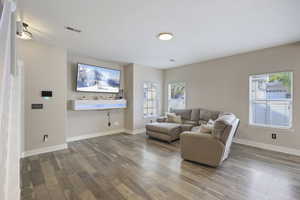 Living room with wood-type flooring, baseboards, and visible vents