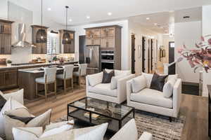Living area with recessed lighting, light wood finished floors, and vaulted ceiling