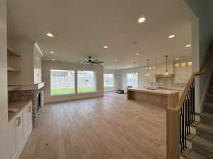 Kitchen featuring open shelves, light wood-style floors, recessed lighting, white cabinets, and ceiling fan with notable chandelier