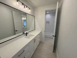 Bathroom with vanity, baseboards, and shower / tub combination