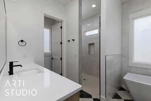 Bathroom with plenty of natural light, a soaking tub, a walk in shower, double vanity, and recessed lighting