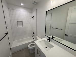 Bathroom with visible vents, tile patterned floors, vanity, toilet, and washtub / shower combination