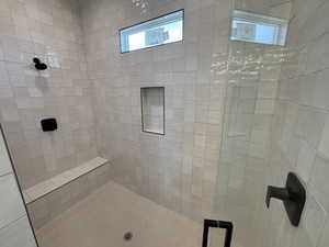 Bathroom with plenty of natural light and a tile shower