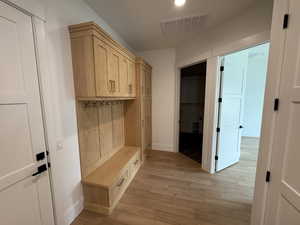 Mudroom with baseboards, visible vents, and light wood-style flooring