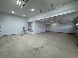 Garage featuring water heater and baseboards
