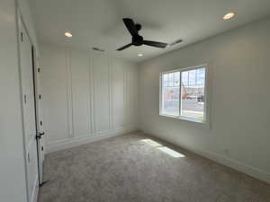 Carpeted spare room featuring ceiling fan, recessed lighting, and visible vents