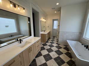 Full bath with a sink, tile patterned flooring, a soaking tub, and visible vents
