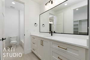 Bathroom with toilet, vanity, baseboards, shower / bath combo with shower curtain, and recessed lighting