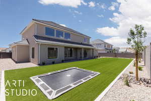 Rear view of house featuring a trampoline, stucco siding, and a patio area