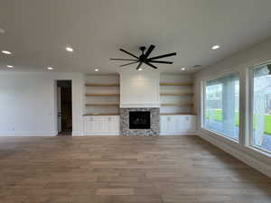 Unfurnished living room with baseboards, light wood finished floors, a ceiling fan, and recessed lighting