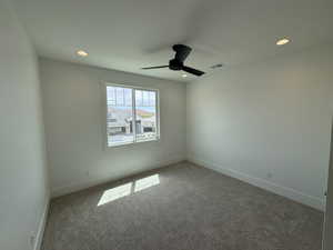 Carpeted empty room featuring baseboards, recessed lighting, ceiling fan, and visible vents