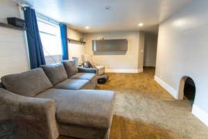 Carpeted living room featuring recessed lighting and baseboards