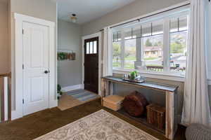 Carpeted entryway featuring baseboards