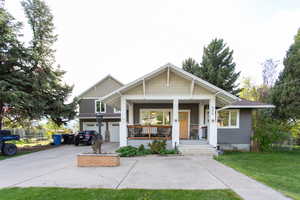 Craftsman-style home with an attached garage, driveway, covered porch, and a front yard