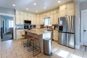 Kitchen with a kitchen island, stainless steel appliances, a wealth of natural light, and cream cabinetry