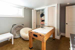Recreation room featuring baseboards and carpet