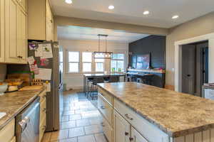 Kitchen with recessed lighting, appliances with stainless steel finishes, light tile patterned flooring, and a kitchen island