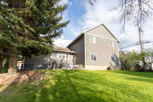 Back of property with a lawn and a patio