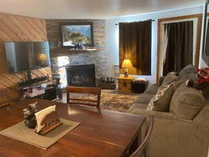 Living room featuring a stone fireplace and wood finished floors
