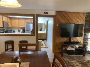 Kitchen with wood finished floors, a breakfast bar, stainless steel appliances, light countertops, and a peninsula