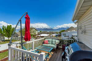 Wooden terrace with a residential view, fence, a mountain view, and area for grilling