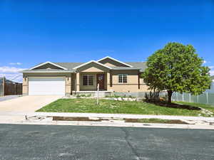 View of front facade with stucco siding, fence, and a garage