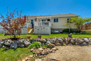 Back of property with fence, a pergola, a deck, stairs, and a yard